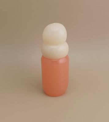 زجاجة وردية اللون بغطاء أبيض أرزي لعطر البنات